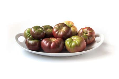 Organic heirloom Brandywine tomatoes on a plate, isolated on whiteの写真素材