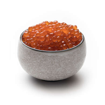 Red salmon caviar in a traditional Japanese cup, isolated on whiteの写真素材