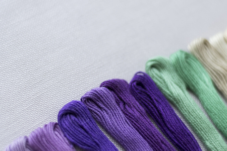 Multi-color embroidery threads on white canvas. Place for text. Macroの写真素材