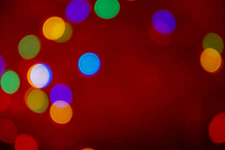 Defocus multicolored lights. Red bokeh background. Abstract christmas textureの写真素材