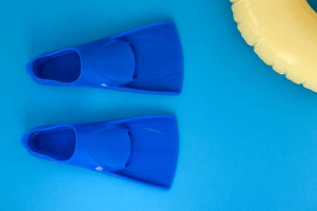 Blue flippers on a blue background. Flat lay. Copy spaceの写真素材
