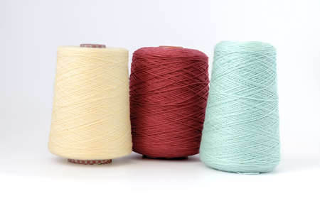Multicolors bobbins of wool yarn for hand and machine knitting on a white background.の写真素材