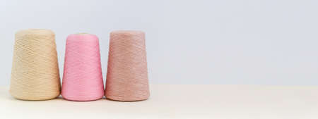 Bobbins of yarn in pastel colors. Copy space background