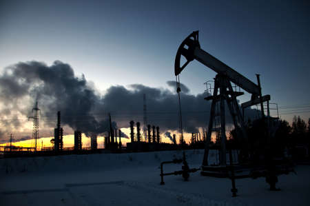 oil pump on  background of  industrial landscape and winter sky in  smokeの写真素材