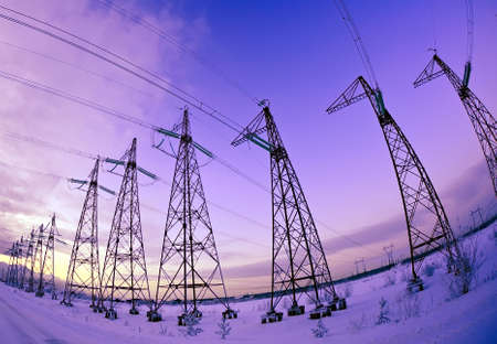 Electric pylons silhouettes against a background of purple sunset sky (winter view)の写真素材