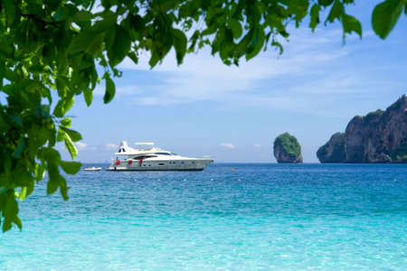 White motor yacht on the background of turquoise water and rocksの写真素材