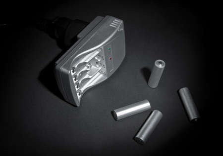 silvery empty battery recharger on a black background.の写真素材