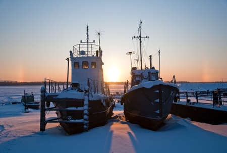 Ships covered with snow on coast Ob River, await  season of navigation. winter sunset, Siberia, Surgut city.の写真素材