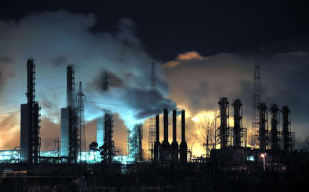 A brightly lit industrial site at night with plumes of smoke coming from chimneys.  Russia, Western Siberia.の写真素材
