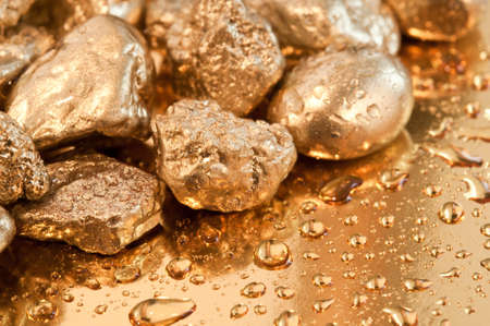 shiny gold nuggets and water drop background. closeup.の写真素材