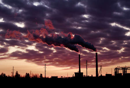 Pollution spewing into the air from industrial chimneys, at sunset.
の写真素材