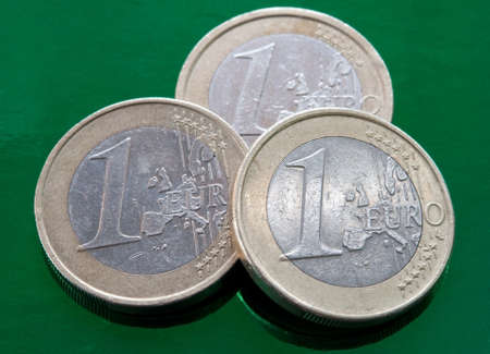 three euro coins on a green background. closeup.の写真素材