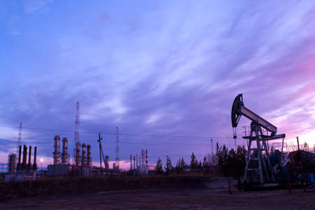 oil pump on  background of  industrial landscape and sunset sky