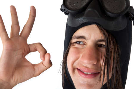 attractive teenager with long wet hair, wearing a diving mask, showing ok, isolated on a white backgroundの写真素材