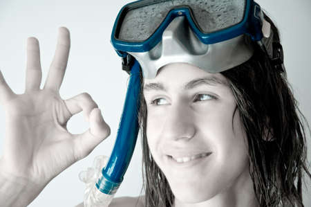 attractive teenager with long wet hair, wearing a diving mask, showing ok. monochrome.の写真素材