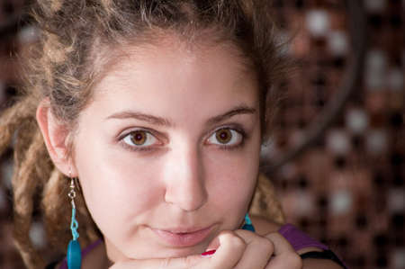 portrait of a young girl with dreadlocks on the background of a decorative mosaic. big eyes. blue earrings.の写真素材