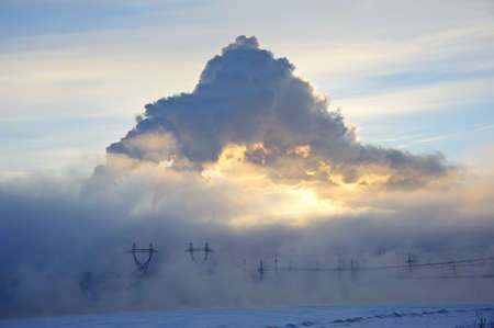 Power Plant Smoke Stacks and Plume on a Snowy evening. Winter sunset. Surgut, western Siberia, Russiaの写真素材