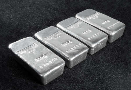 Processing and global trading of precious metals. Silver bars on a black background. Closeup.の写真素材