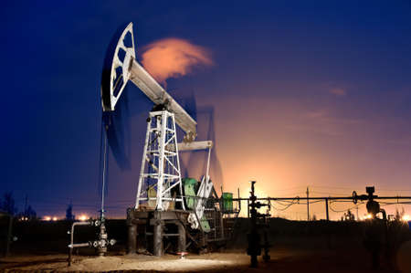 Oil pump-jack in action. Gas torches. Night view. Long exposure.の写真素材