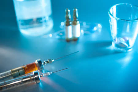 syringe with dose. medication vials, pills closeup, selective focus.の写真素材