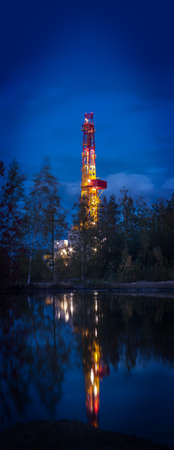Night landscape with the drilling rig. Vertical panorama. Selective focus, shallow depth of field.の写真素材