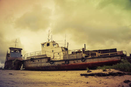 Old wrecked boat on the coast. Autumn sky background.の写真素材