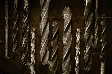 Various drills on a metallic, old, wet background. Macro. Toned sepia.の写真素材