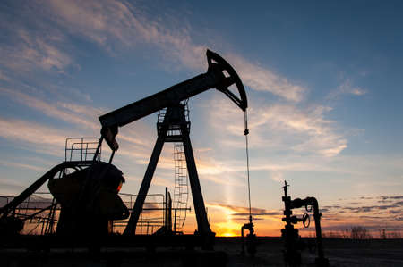 Silhouette oil pump jacks at sunset sky background.の写真素材