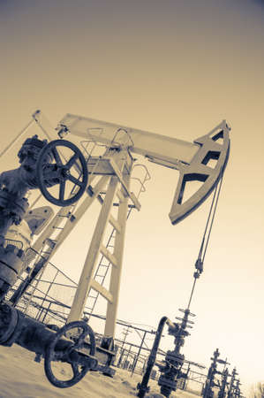 Oil pump jack and wellhead in the oilfield. Oil and gas concept.の写真素材