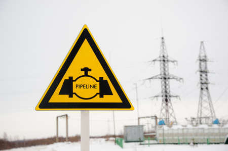 Pipeline sign with hight voltage power transmission tower. Power supply, oil and energetics concept.の写真素材