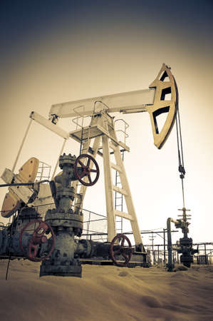 Oil pump jack and wellhead in the oilfield. Oil and gas concept.の写真素材