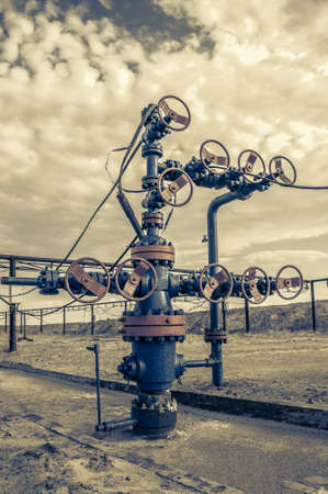 Wellhead with valve armature. Oil and gas industry concept. Industrial site. Toned.の写真素材