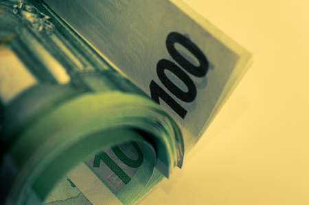 Euro money, Euro cash background. Banknotes of the european union on a white background. 100 euros roll.の写真素材