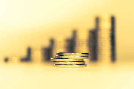 Stack of golden coins macro. Rows of coins for finance and banking concept. Economy trends background for business idea.の写真素材