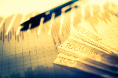 Finance background with money, stock market chart, graph and pen. Economy and business concept.の写真素材