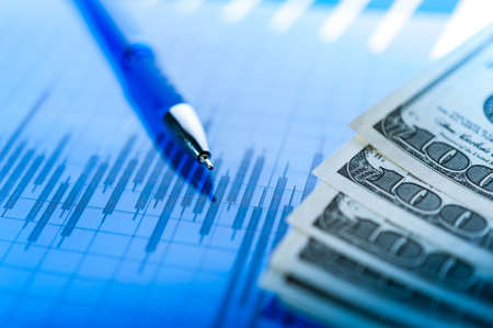 Finance background with money, stock market chart, graph and pen. Economy and business concept.の写真素材