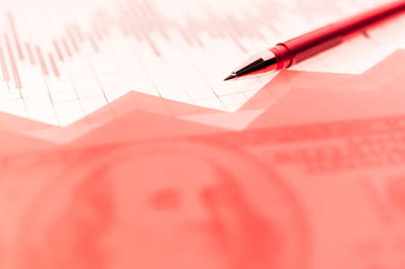 Finance background with money, stock market chart, graph and pen. Living coral toned.