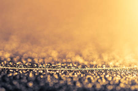 Abstract shiny golden background with bokeh and thin line. Glitter glowing texture pattern.
