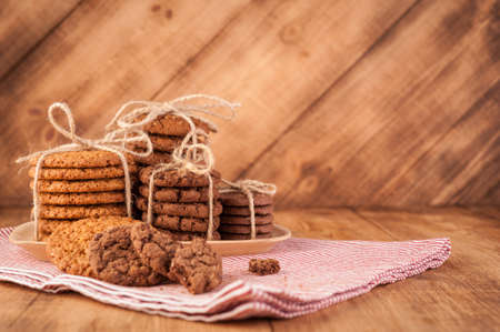 Various shortbread, oat cookies, chocolate chip biscuit on dark rustic wooden table.の写真素材