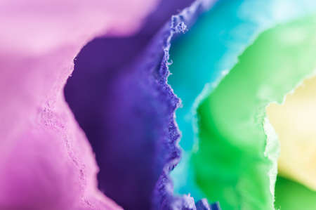 Multi-colored crumpled real vivid paper sheets texture background. Close up. Shallow depth of field.