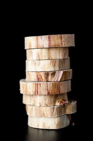 Stacked cross sections of juniper tree trunk isolated on a black background.の写真素材