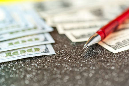 Business and financial background with dollars and pen. Abstract bookkeeping background.