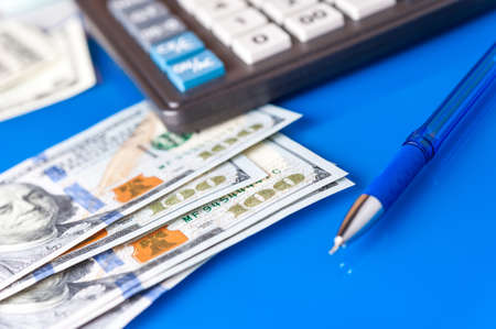 Business and financial background with dollars, pen and calculator. Bookkeeping background.の写真素材