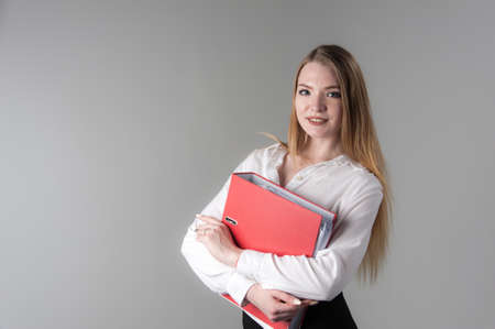 Portrait of a young attractive woman with blond hair on a neutral gray background.の写真素材