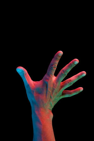 Bright fluorescent colorful hands isolated on a dark background. Close-up.
