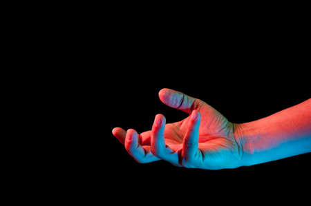 Bright fluorescent colorful hands isolated on a dark background. Close-up.の写真素材