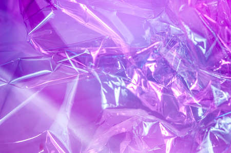 Holographic background in the style of the 80-90s. Real texture of cellophane film in bright acid colors.の写真素材