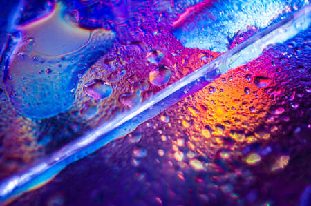 Background in the style of the 80-90s. Real texture of broken glass or ice and drops in bright acid colors.の写真素材