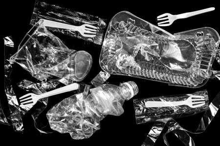 Various disposable crumpled plastic garbage isolated on a black background. Concept of recycling...
