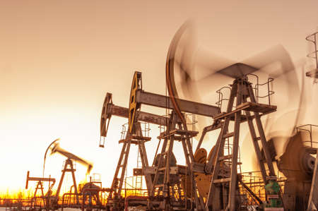 Oil pump rig. Oil and gas production. Oilfield site. Pump Jack are running. Drilling derricks for fossil fuels output and crude oil production. War on oil prices. Global coronavirus COVID 19 crisis.の写真素材